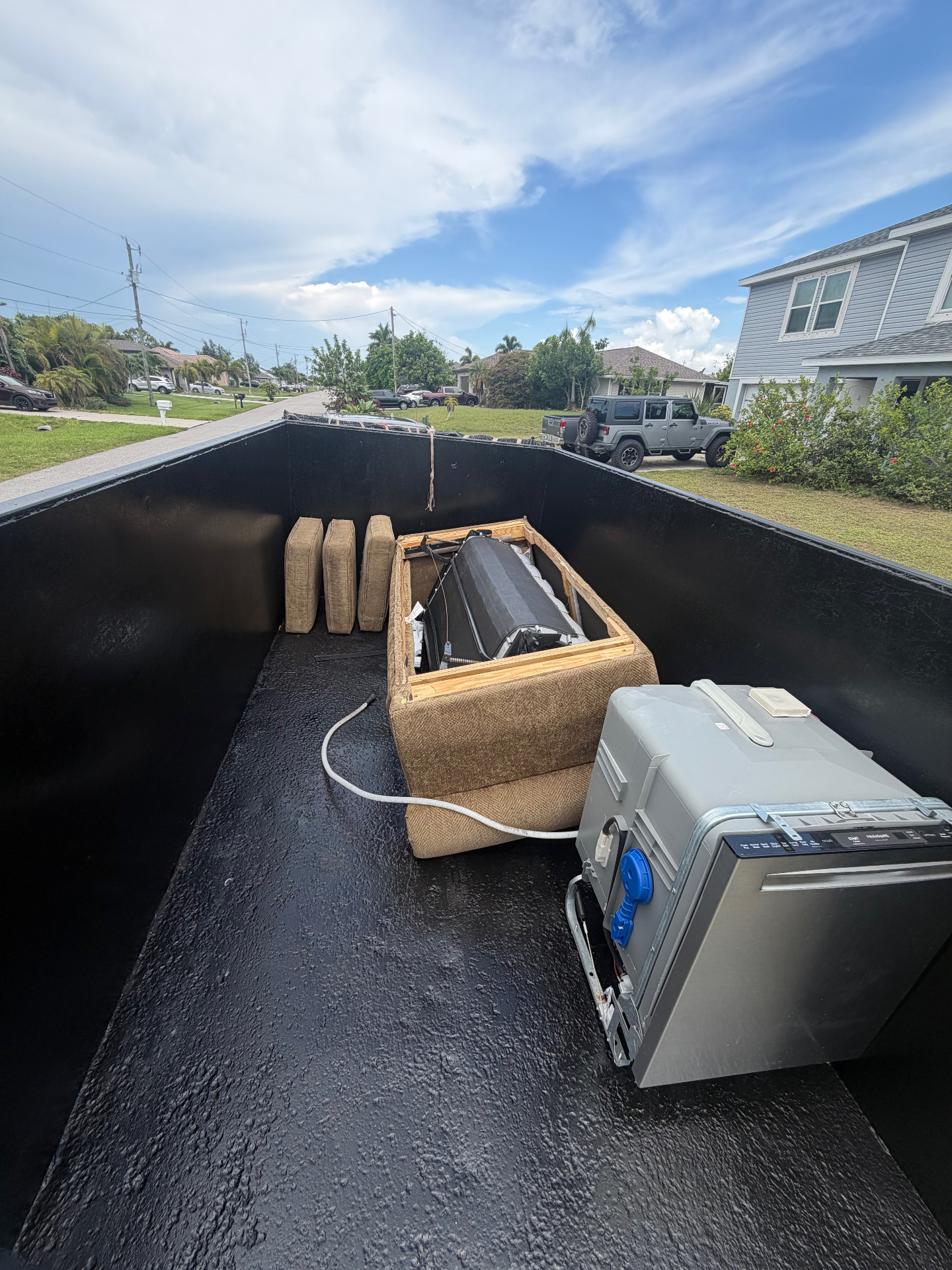 Junk removal trailer loaded with furniture and appliances in Southwest Florida